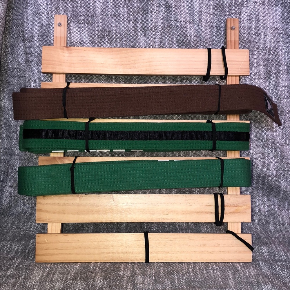 Wood martial arts display rack. Three belts included. Made by Lillian Vernon.